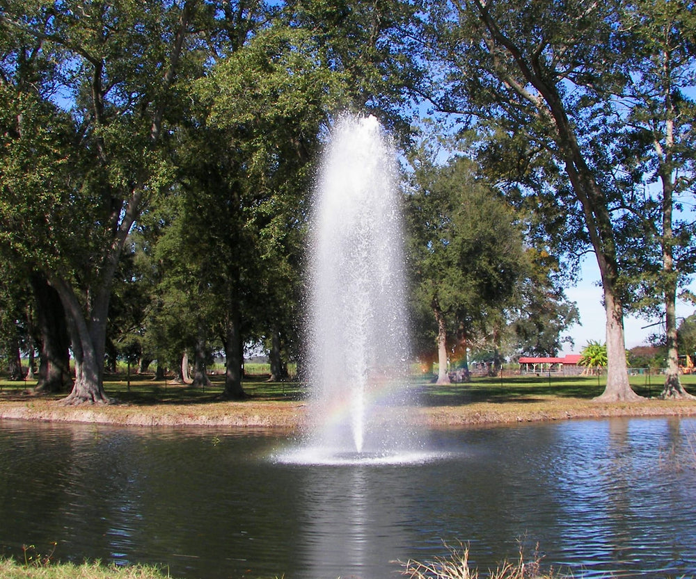 2 HP Kasco J-Series decorative fountain creating a tall water display in a tree-lined pond.