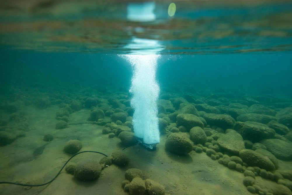 Kasco RobustAire bottom-diffused pond aeration system creating bubbles at the water surface.